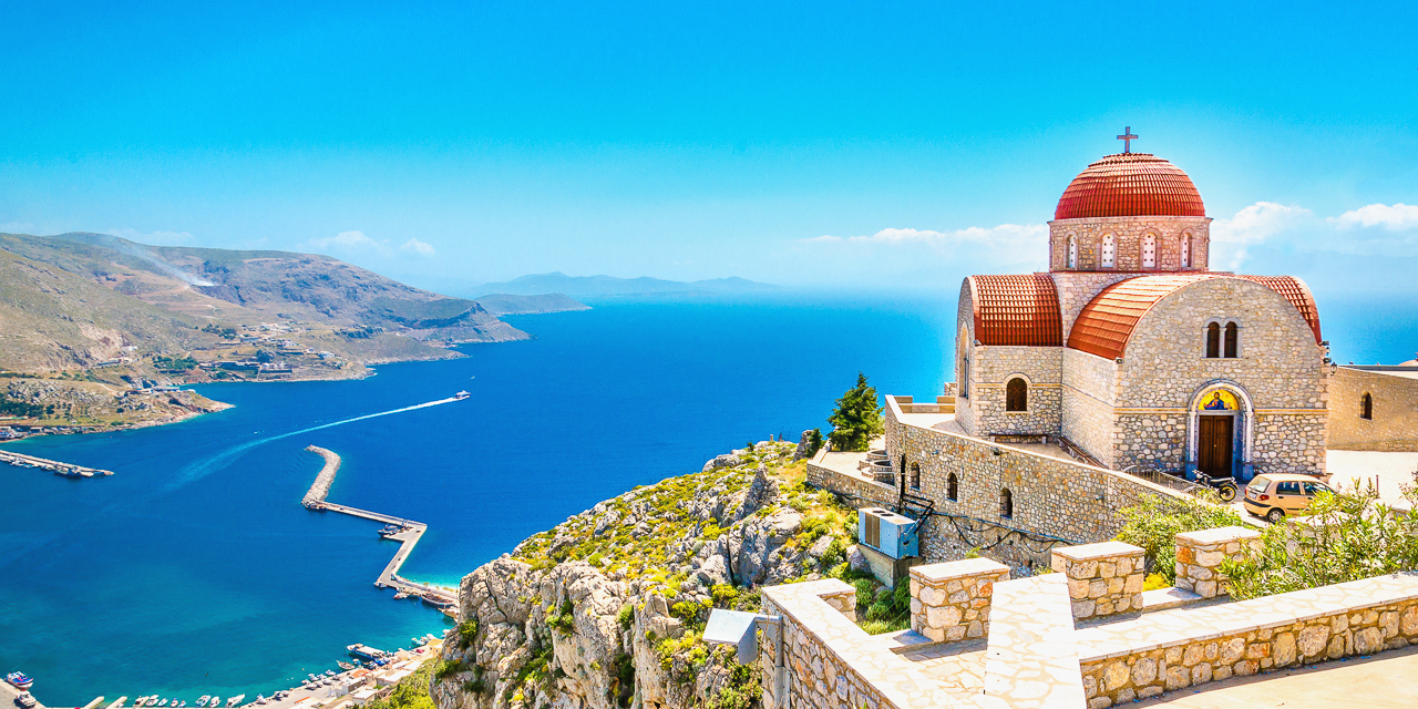 Amazing view on remote church with red roofing on the Cliff of the sea, Greece